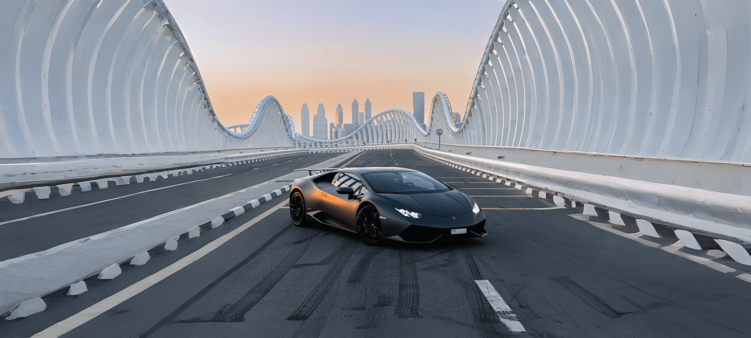 A Lamborghini HuracΓ‘n on Dubai's Meydan Bridge at sunset