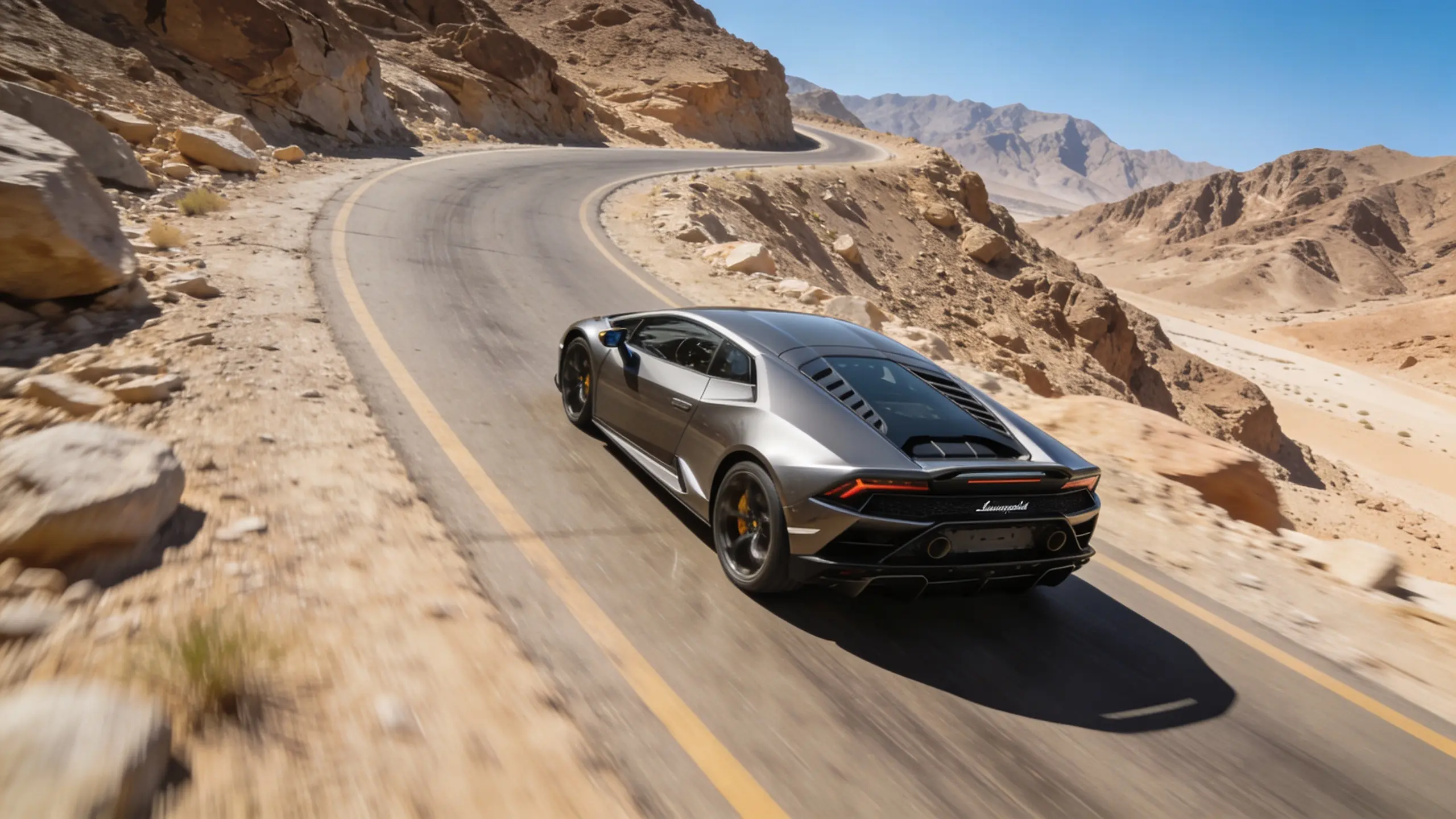 Lamborghini Huracan driving on Hatta mountain road with Hajar Mountains in background